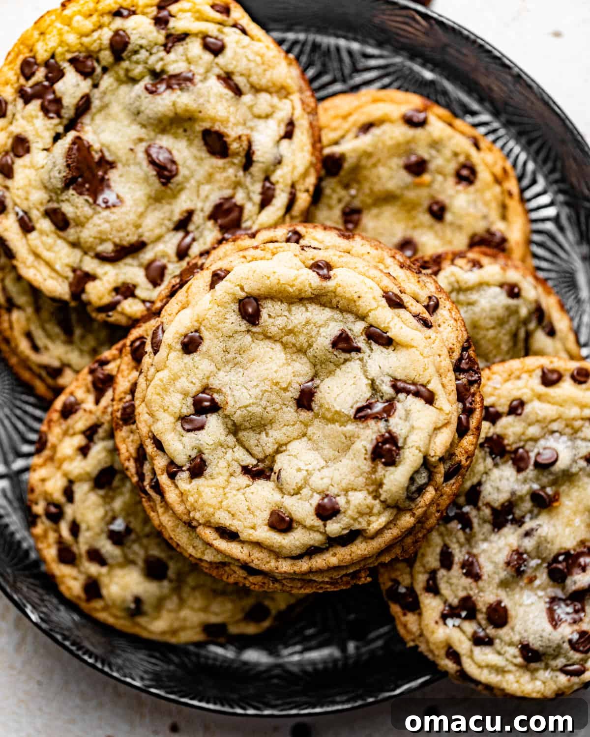 Freshly baked chocolate chip sugar cookies, without brown sugar, cooling on a baking pan.