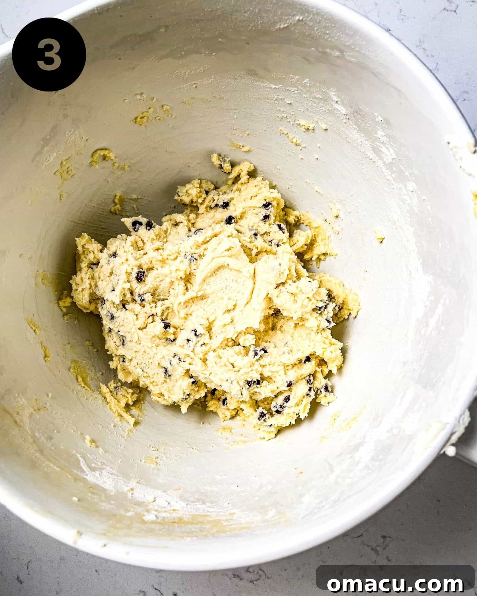 Perfectly mixed chocolate chip sugar cookie batter with folded-in chocolate chips, ready for scooping in a large mixing bowl.