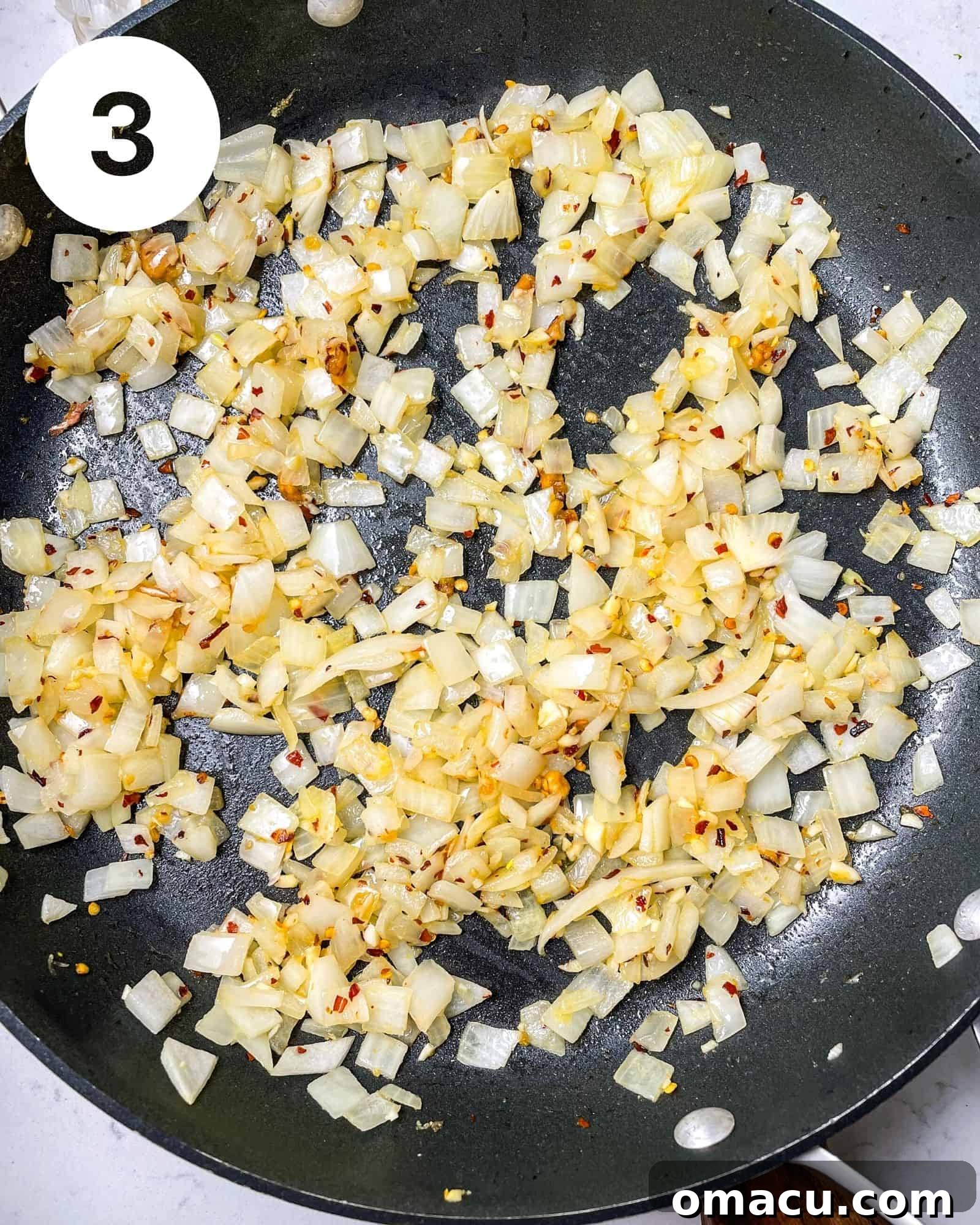 Diced onions, garlic, and various seasonings sautéing in a large pot on the stove.