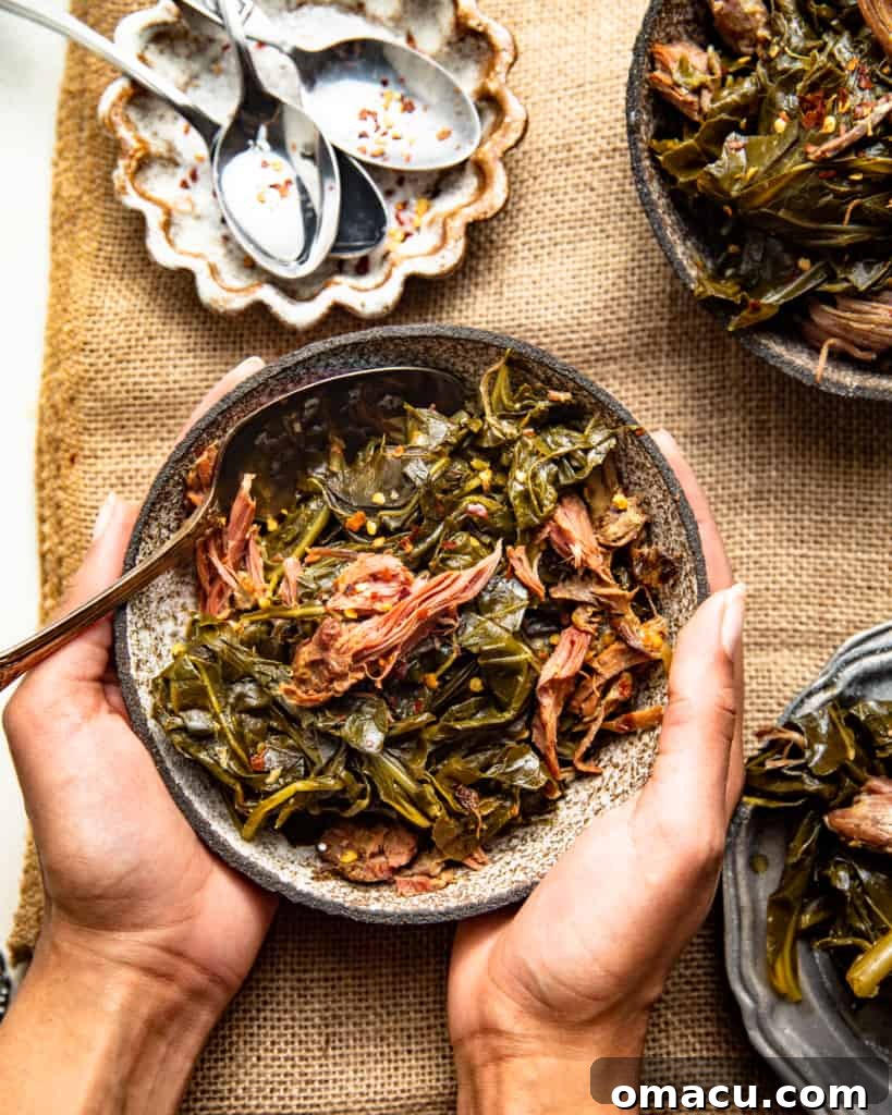 A generous bowl of perfectly cooked slow cooker collard greens, ready to serve with a spoon nestled alongside, showcasing their tender texture.