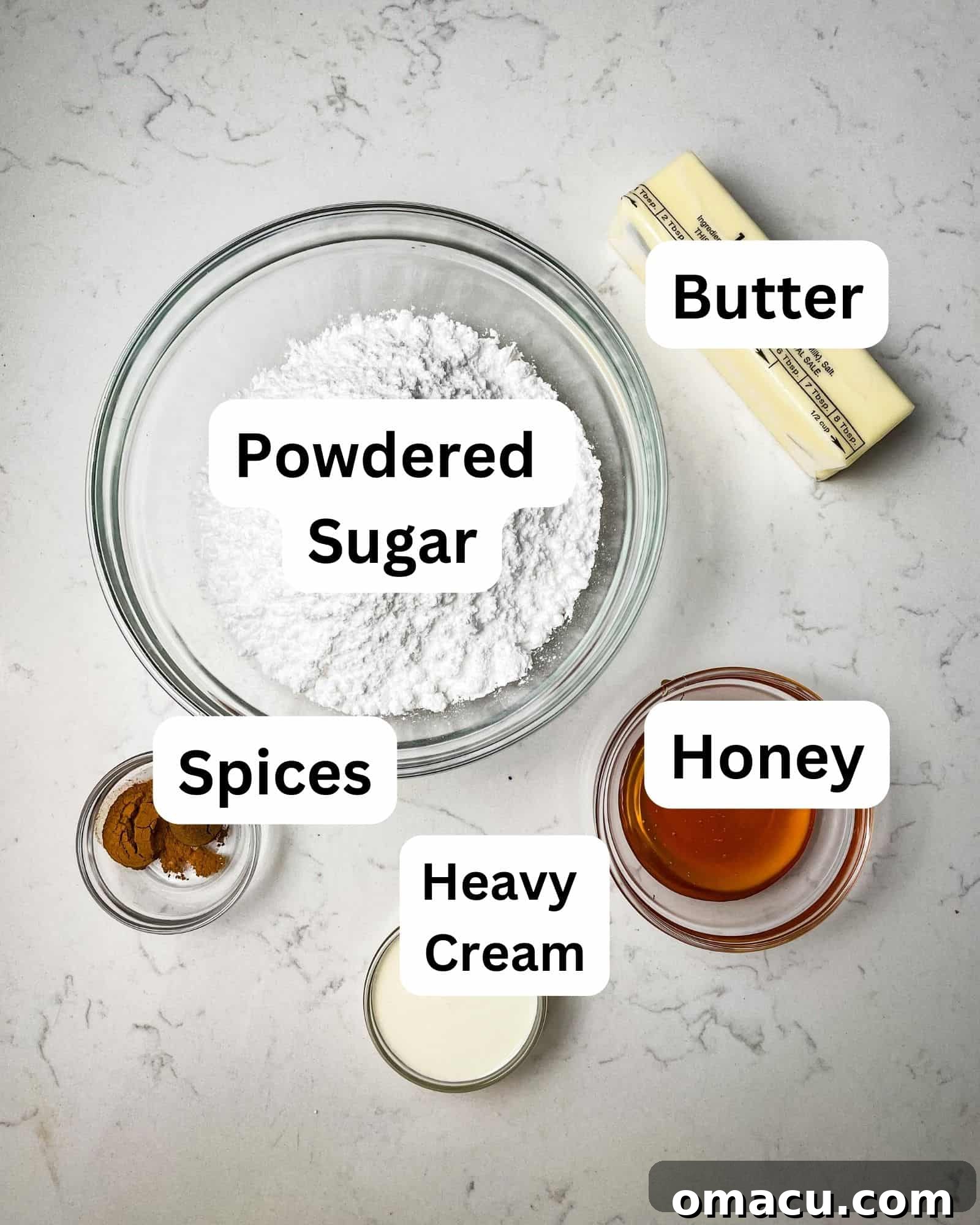 ingredients to make gingerbread macaron filling - butter, powdered sugar, honey, spices, and heavy cream.
