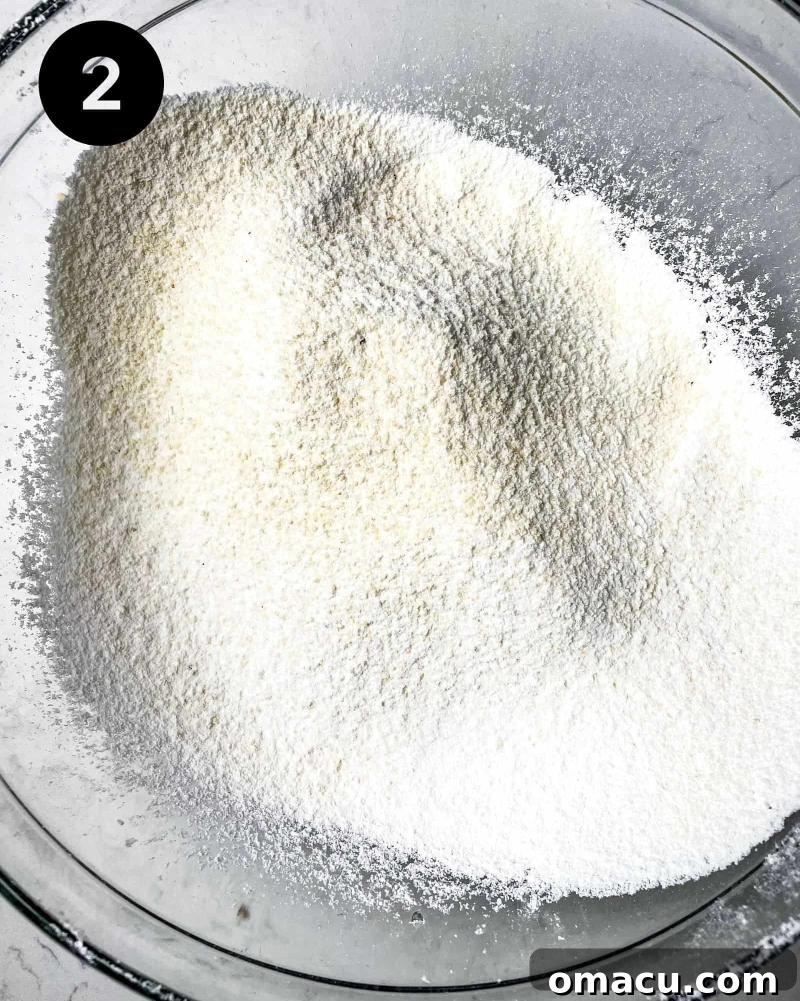 sifted almond flour and powdered sugar mixed with spices in a bowl.