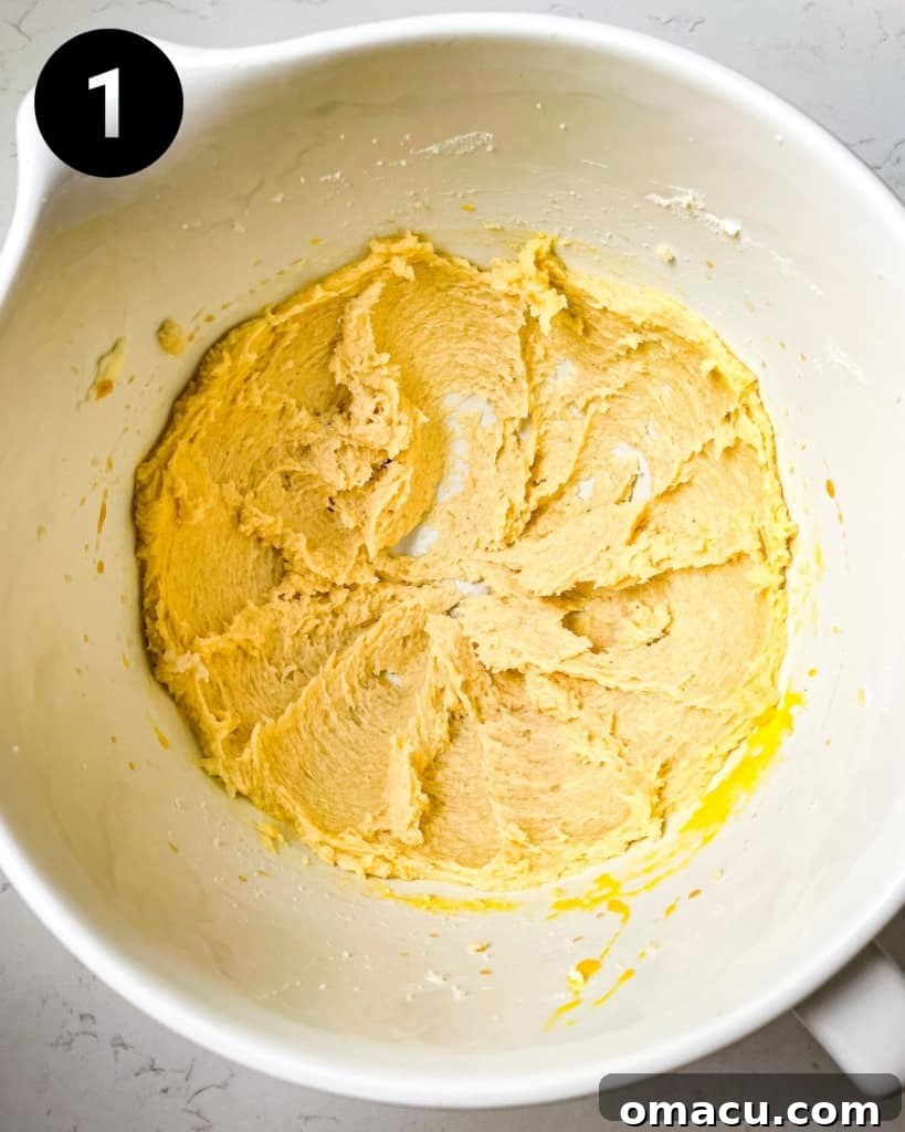 Softened butter and granulated sugar are creamed together in the bowl of a stand mixer, creating a light and fluffy base for the shortbread cookies.