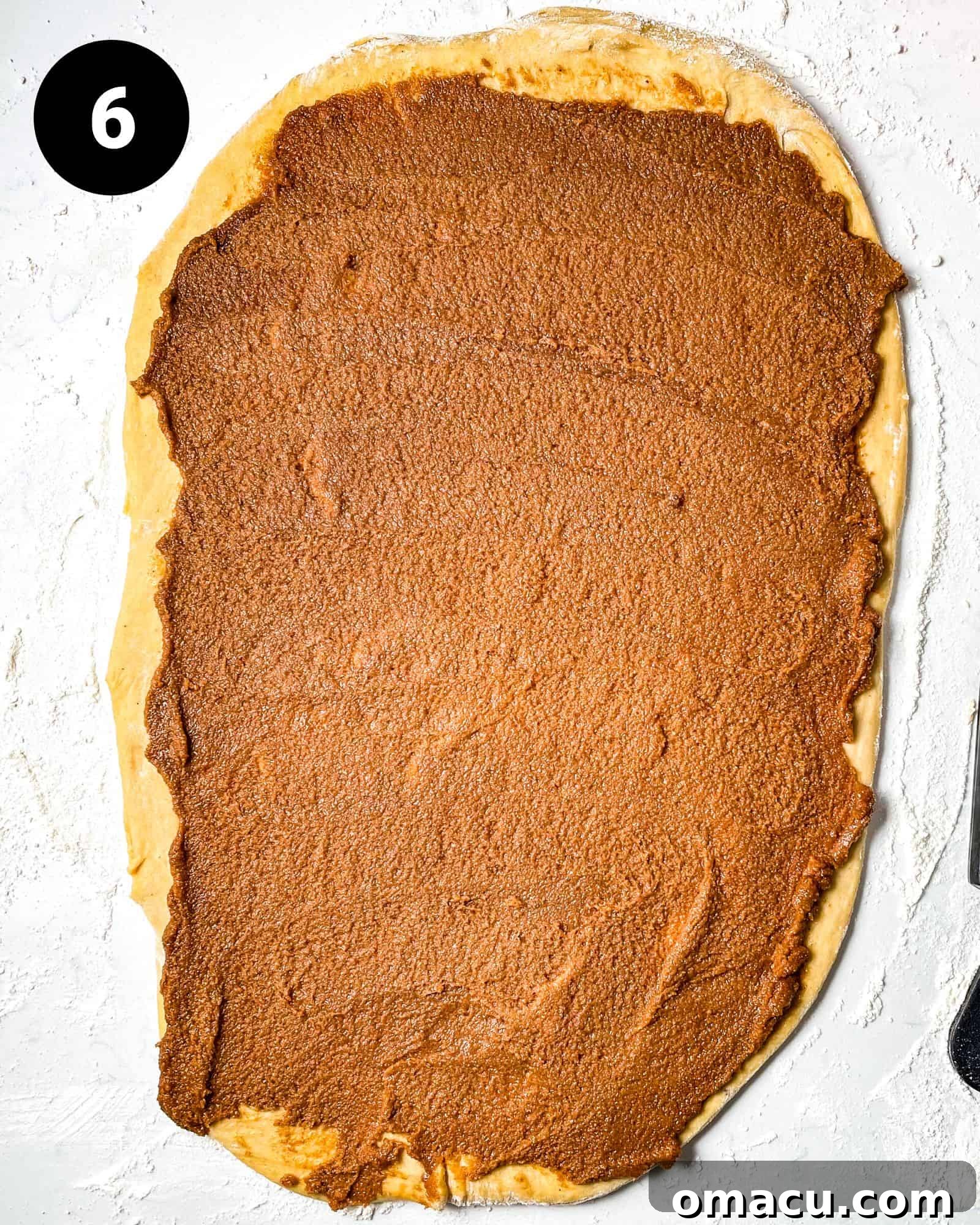 The rolled-out dough, generously covered with the rich cinnamon sugar mixture, ready to be rolled into a log.