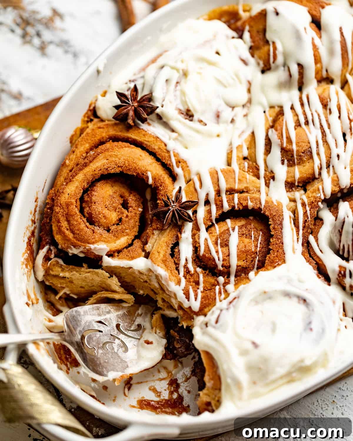 Freshly baked cinnamon rolls in a casserole dish with a pie server ready to serve, perfect for sharing or storing.