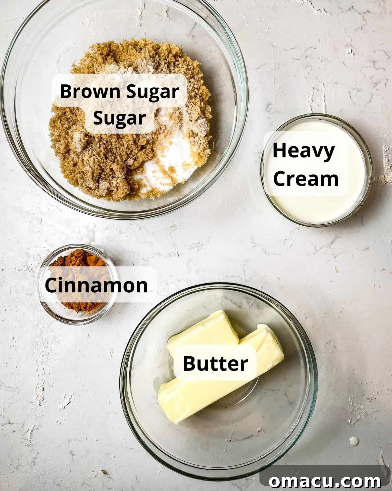 Close-up of ingredients for the cinnamon roll filling: brown sugar, granulated sugar, ground cinnamon, melted butter, and heavy cream.