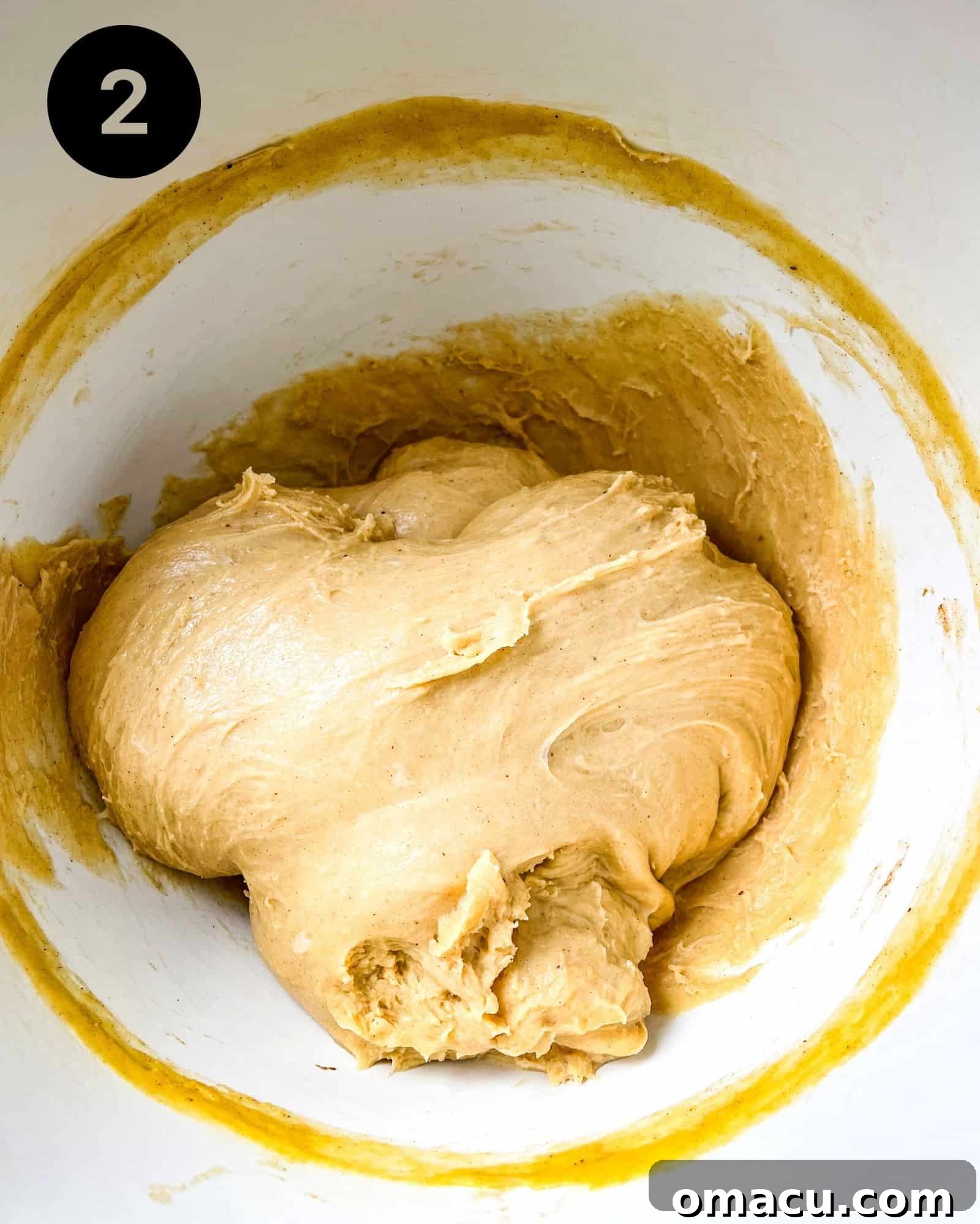 Smooth, elastic brioche dough resting in a lightly oiled mixing bowl, covered for its first rise.
