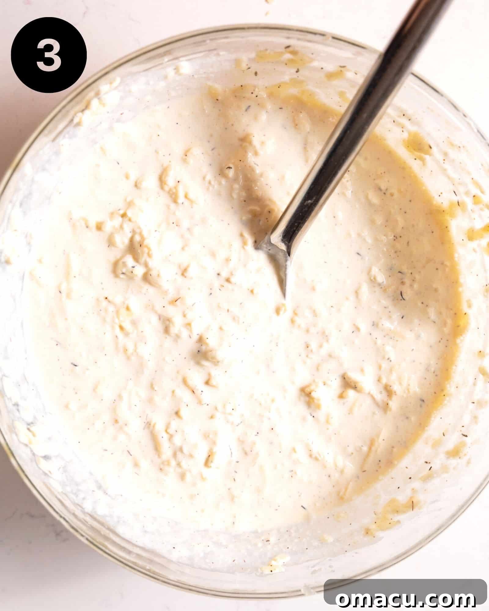 A vibrant mixing bowl brimming with an unctuous blend of grated cheeses, whole milk, heavy cream, and aromatic seasonings, waiting to be combined.