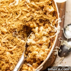 up close photo of a spoon scooping mac and cheese out of a baking dish.