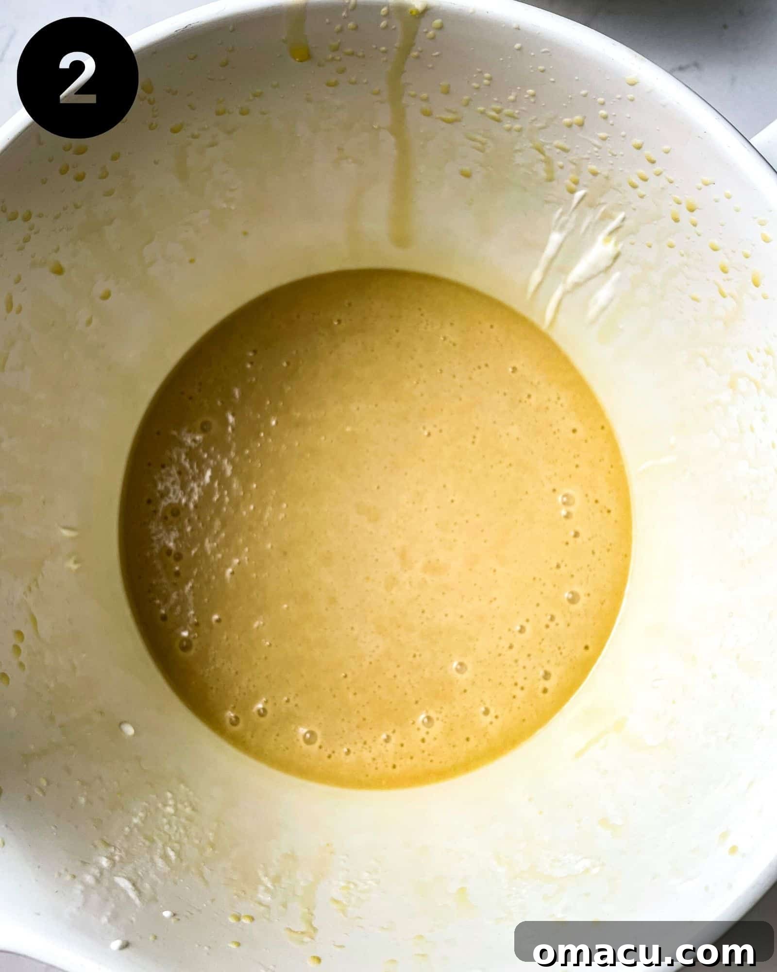 A vibrant assortment of wet ingredients – farm-fresh eggs, creamy sour cream, rich vanilla extract, dark molasses, golden melted butter, fresh milk, and sparkling sugar – expertly whisked together in a bowl, awaiting the dry components.