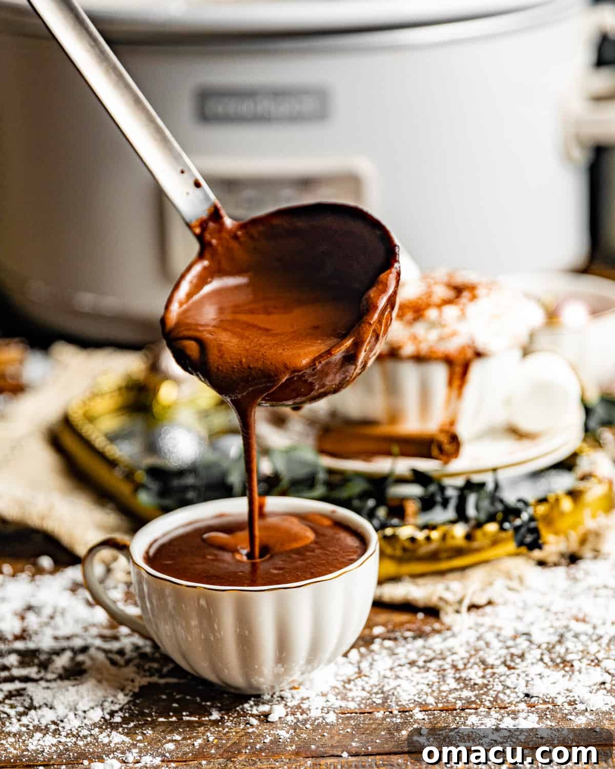A ladle pouring rich hot chocolate into a mug, highlighting the smooth consistency of the drink.