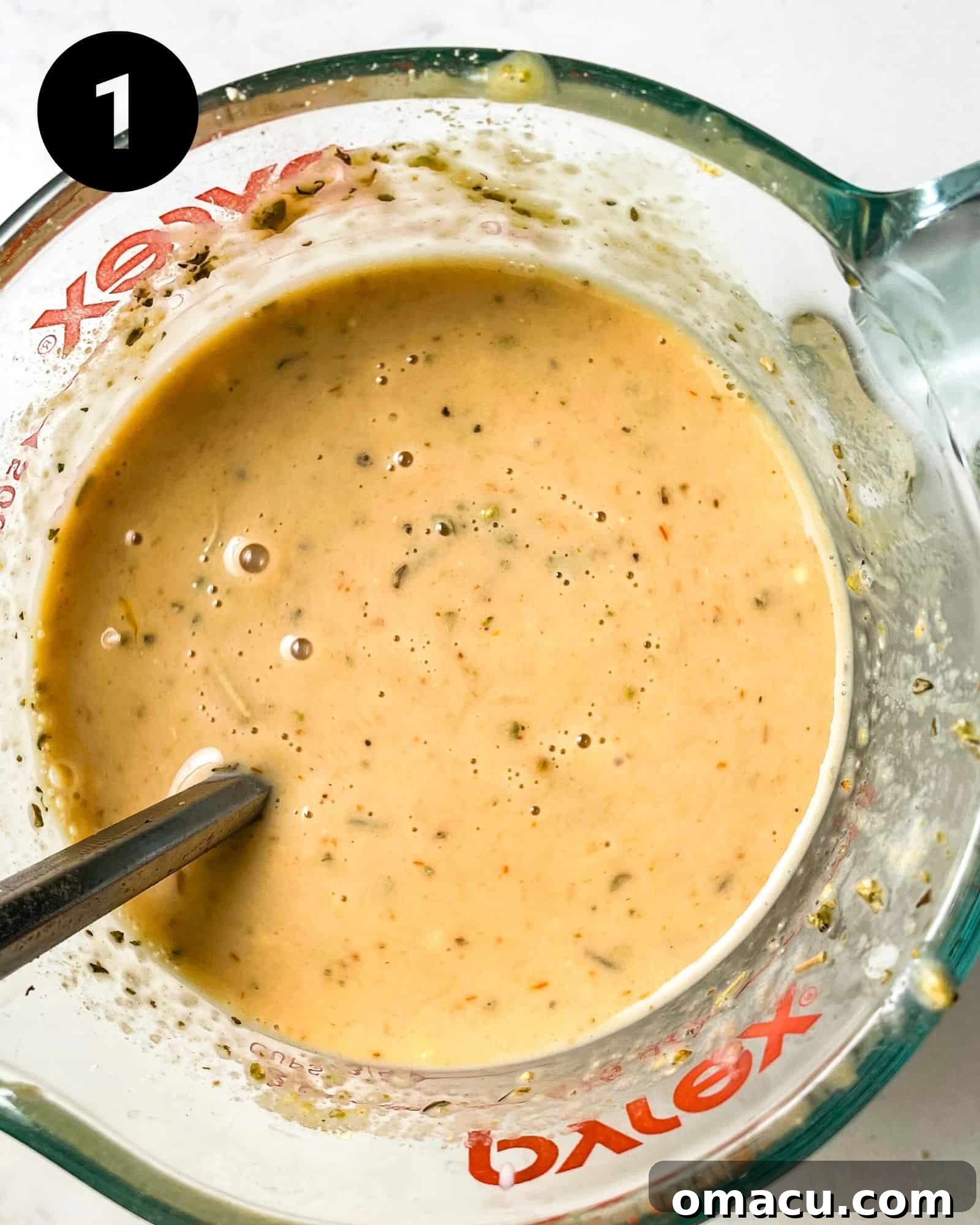 eggs, milk, worestershire sauce, ketchup, and dijon mustard whisked together in a measuring cup.