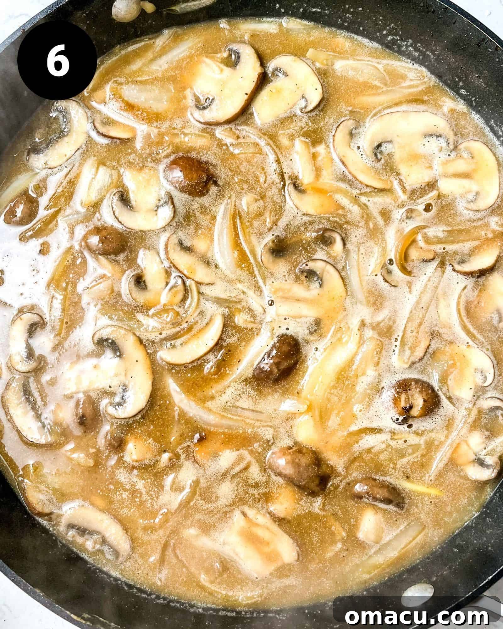 mushrooms and onions in a pan with beef broth.