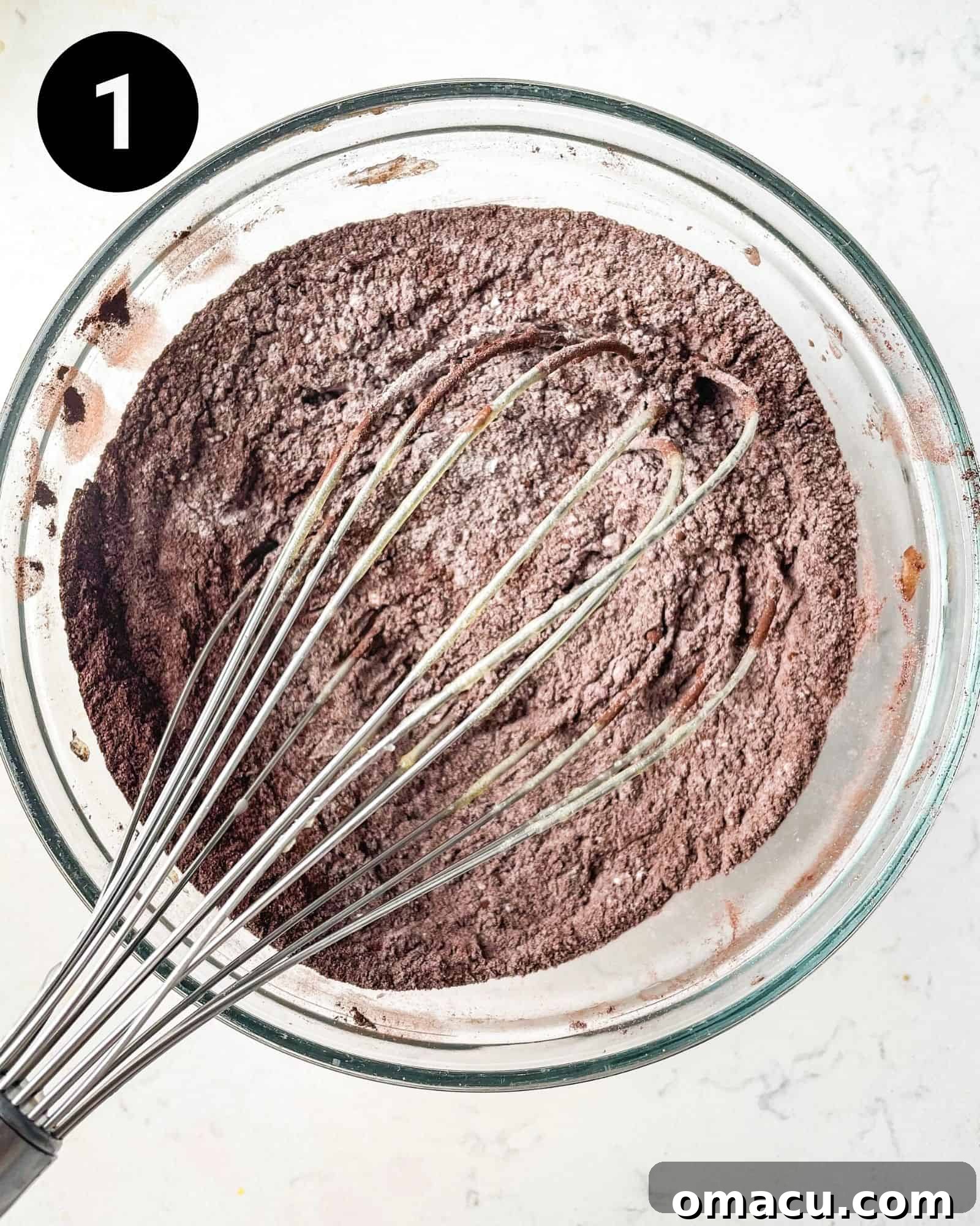 A bowl of dry ingredients for red velvet brownies, featuring cocoa powder, flour, and salt, perfectly whisked together and ready for the wet ingredients.