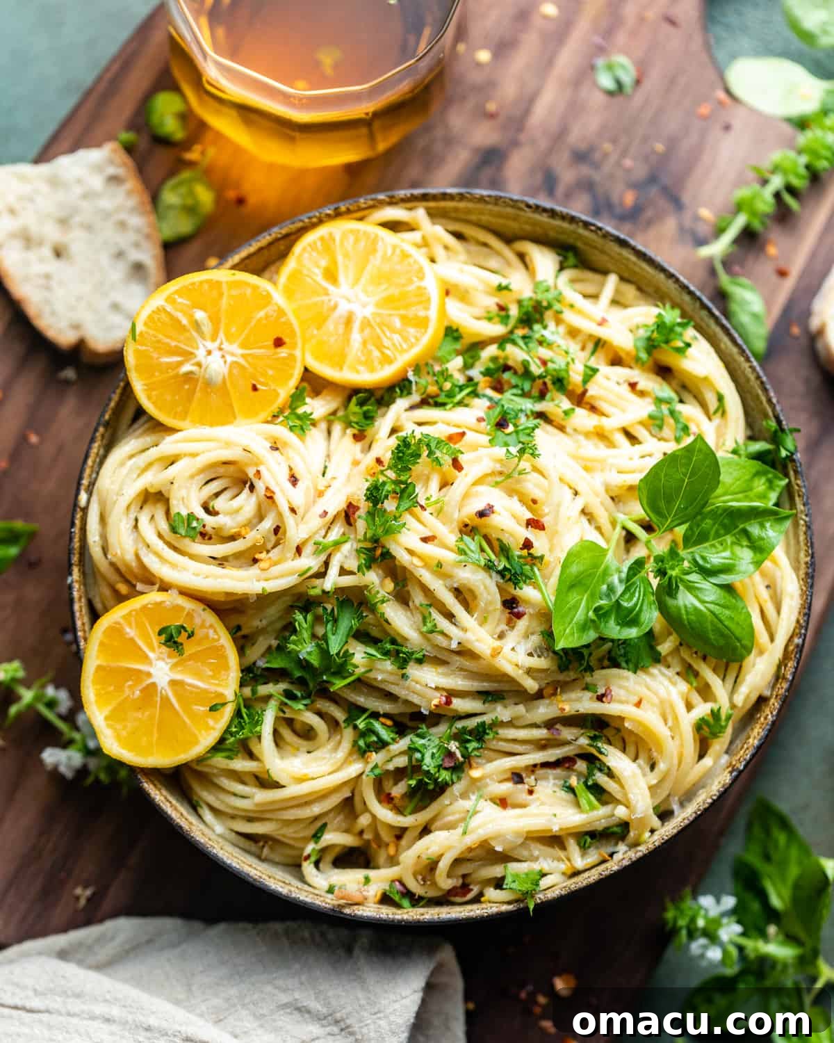 A beautifully presented bowl of lemon garlic pasta resting on a rustic wooden serving board, highlighting its creamy texture and fresh garnish.