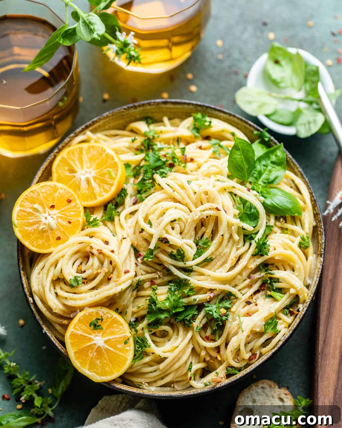 A close-up of lemon garlic pasta served in a bowl, elegantly garnished with delicate lemon slices and fresh basil leaves, highlighting its appetizing appearance.