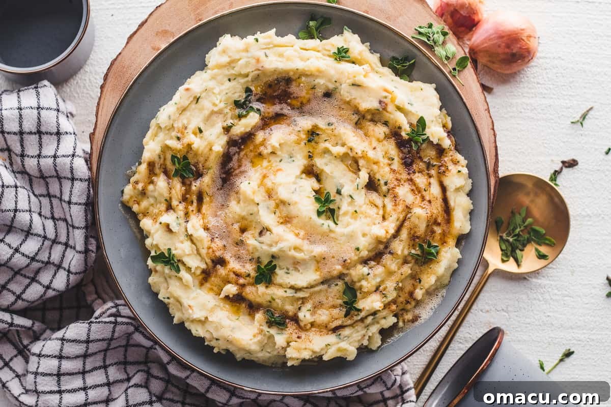 Close-up of creamy Brown Butter and Herb Mashed Potatoes in a bowl, ready to serve.