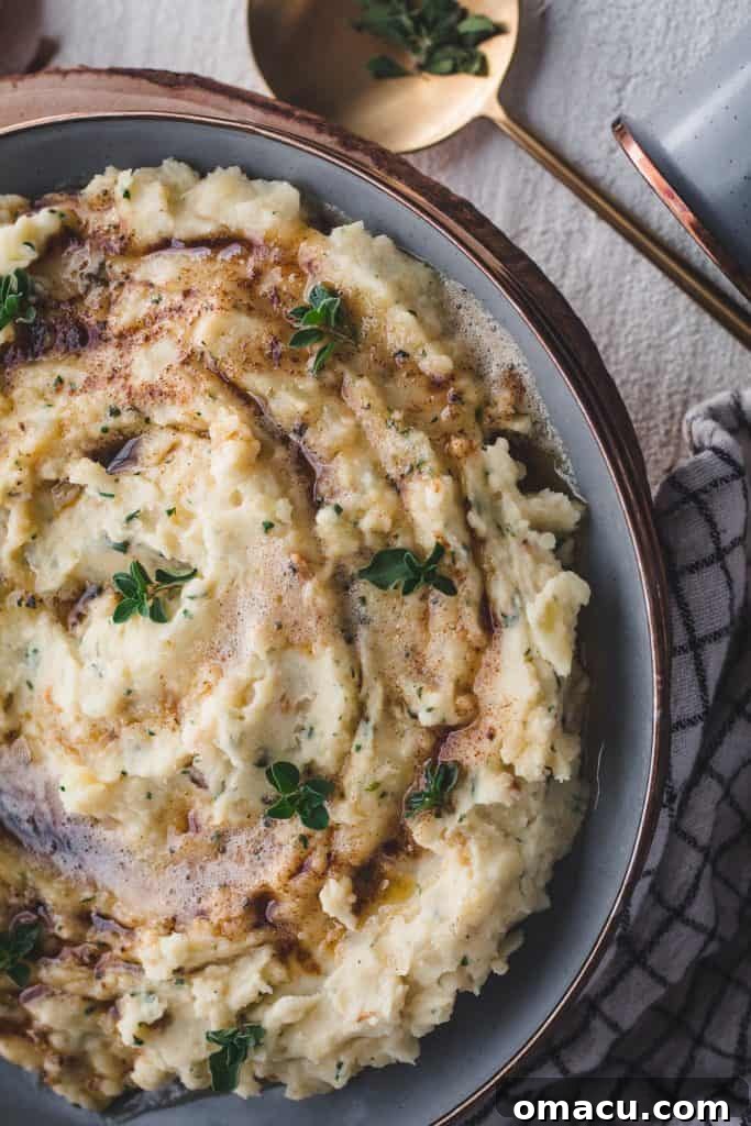 Closeup of fluffy brown butter garlic and herb mashed potatoes in a bowl.