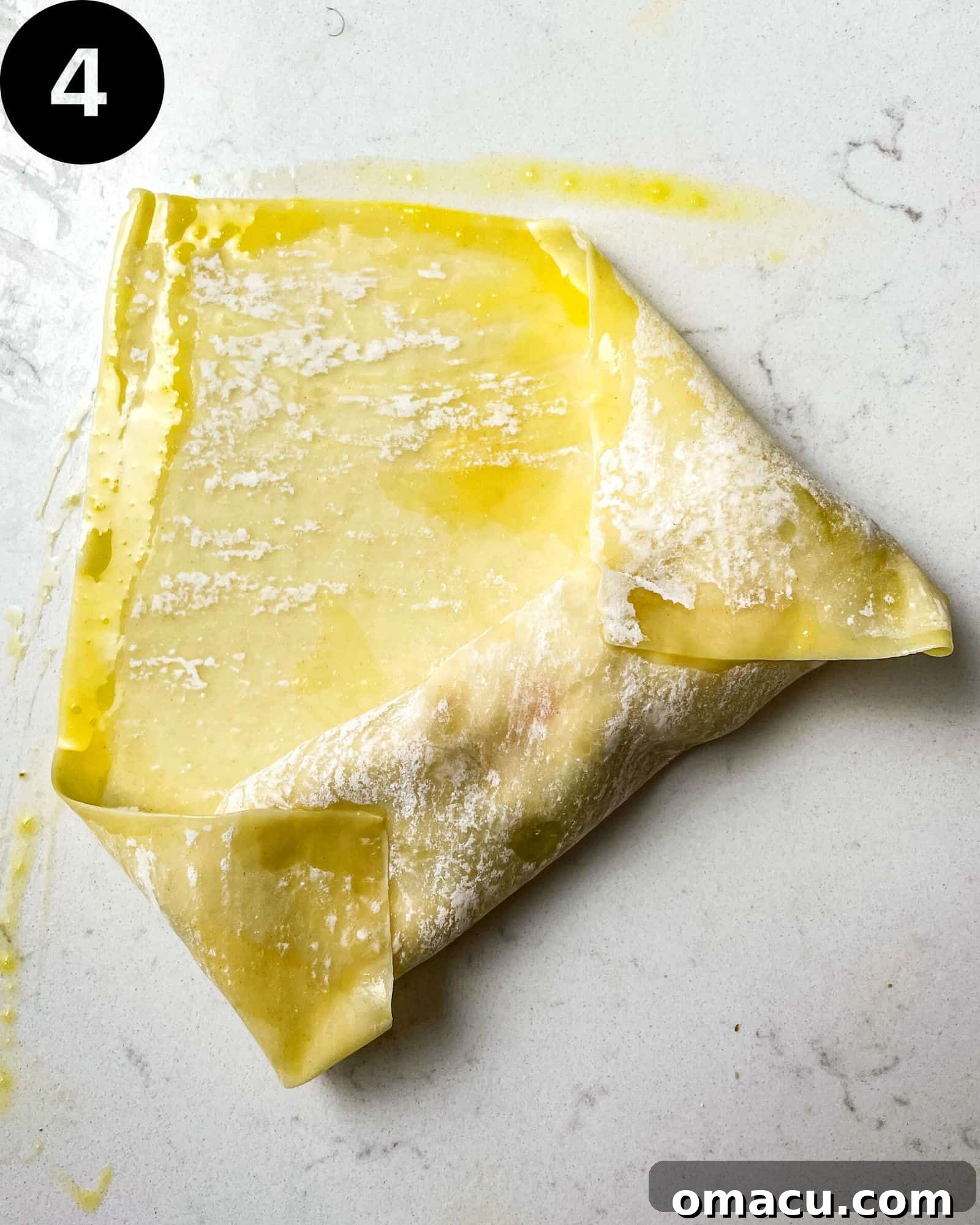 Another stage of egg roll preparation, showing the side corners of the wrapper folded inwards, creating a neat envelope for the filling.