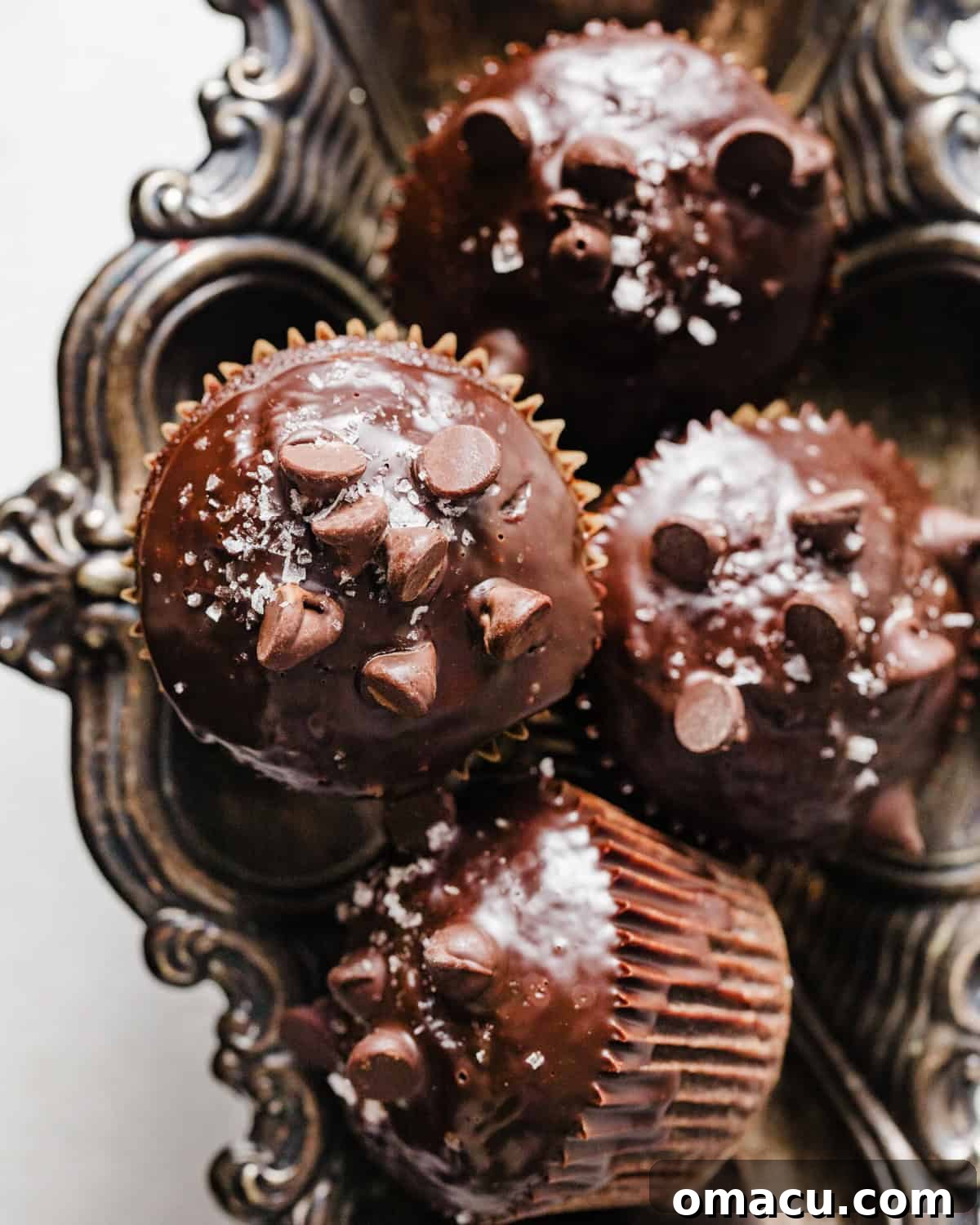 Delicious Triple Chocolate Muffins arranged beautifully on a silver serving plate, showcasing their rich color and inviting texture.