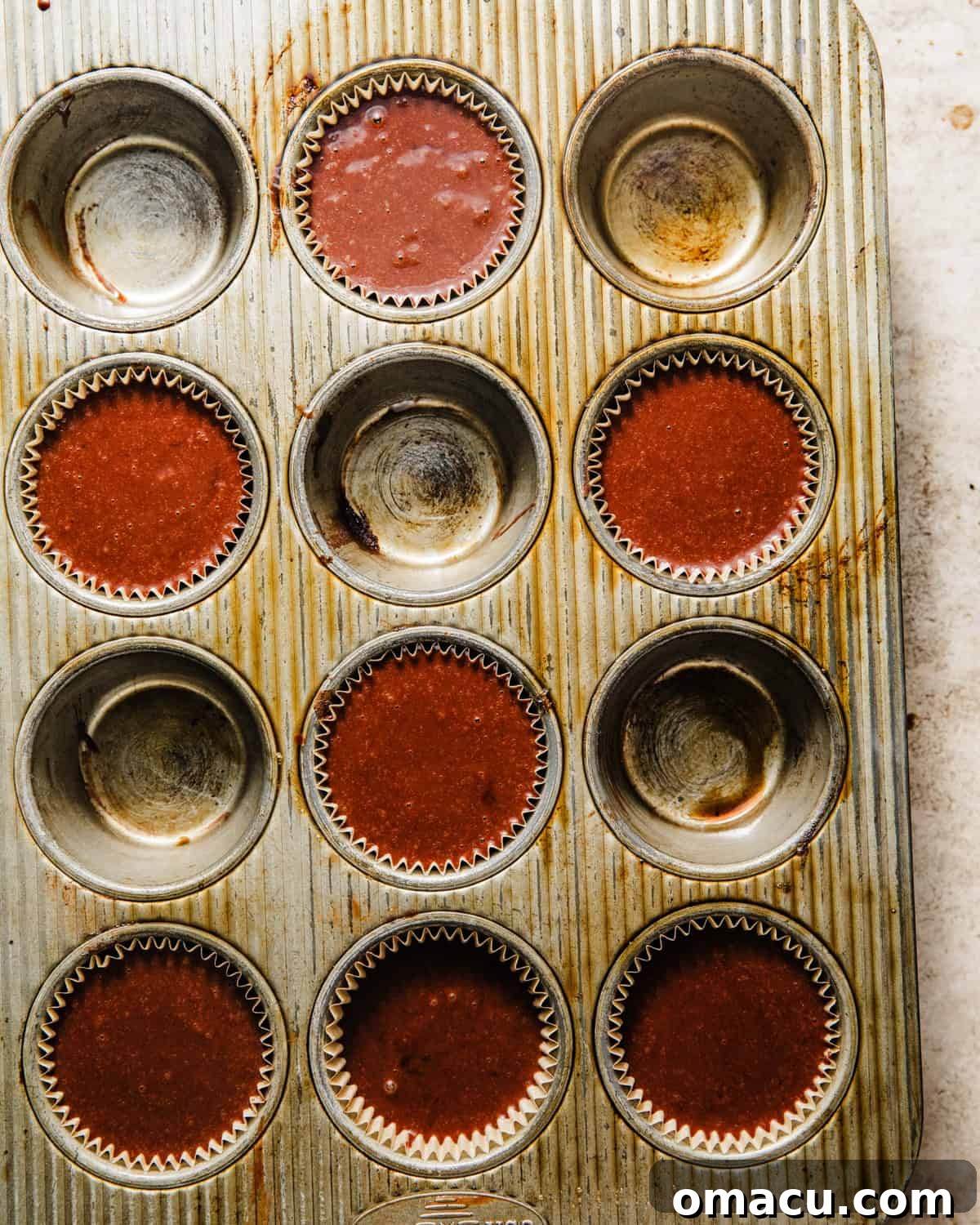 Chocolate muffins baked to perfection in a muffin tin, showcasing their golden-brown tops and rich color.