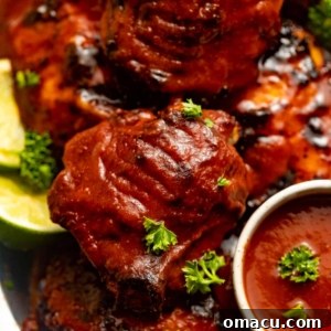 baked chicken thighs covered in bbq sauce on a silver plate.