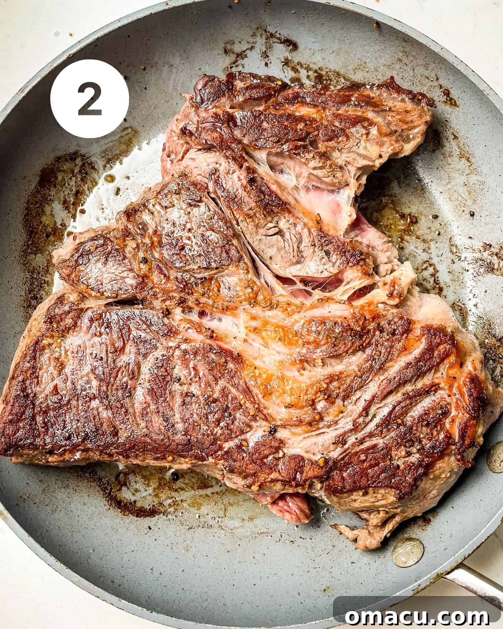 chuck roast seared in a skillet.