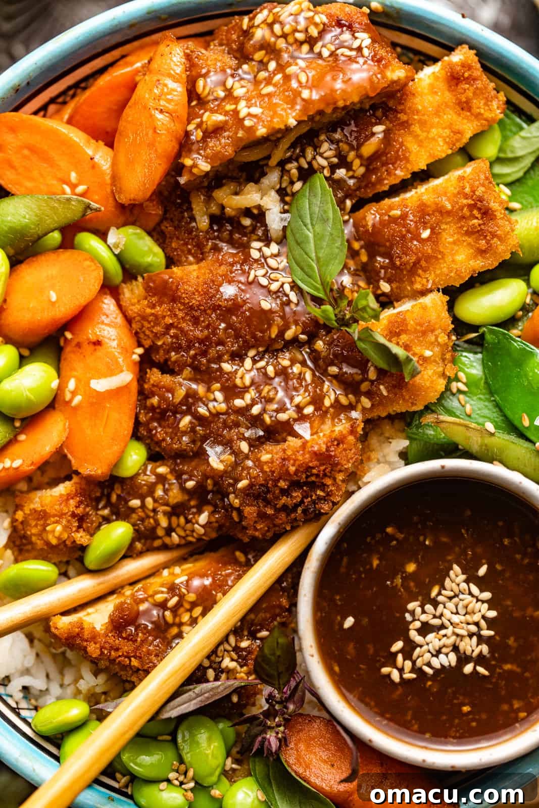 Up close photo of teriyaki chicken rice bowls, highlighting the crispy chicken and fresh vegetables.