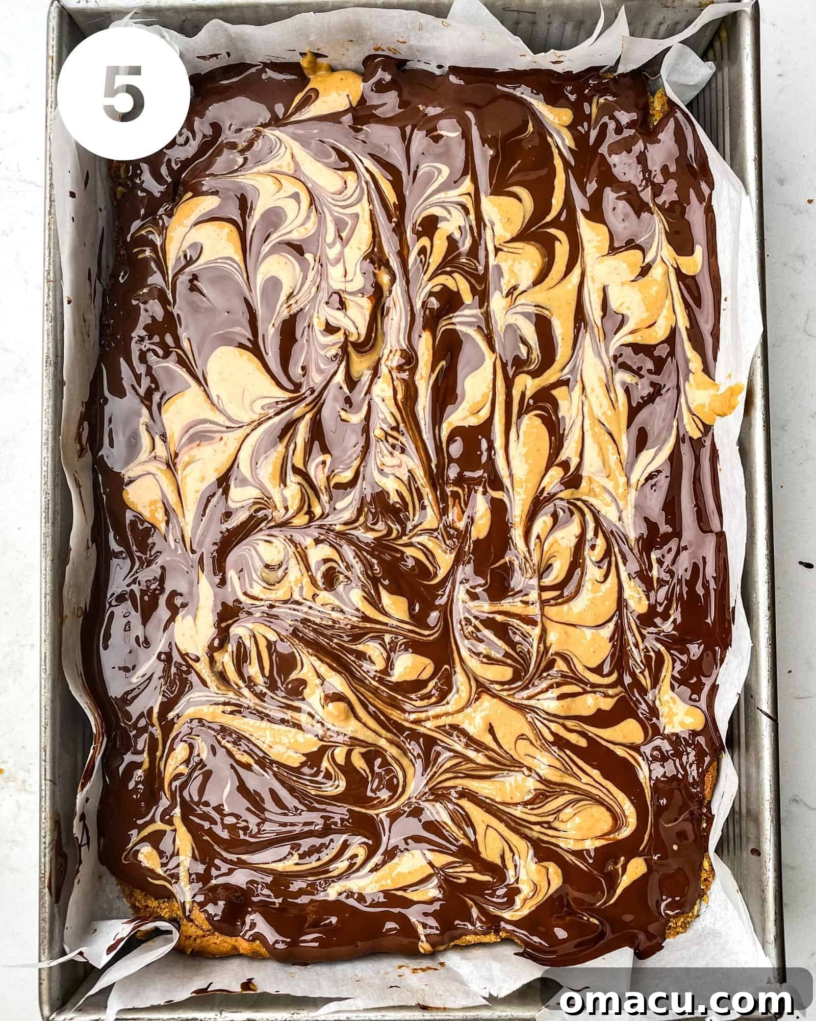 The completed chocolate peanut butter oatmeal bars, with their swirled topping, are shown in the baking pan after chilling.