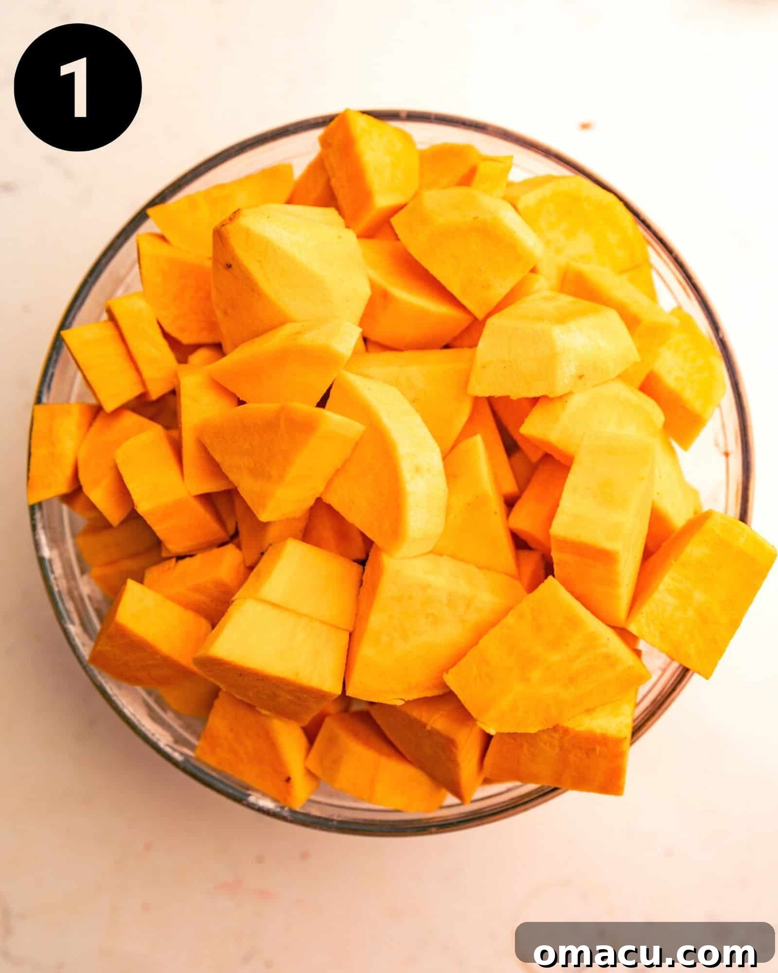 Fresh sweet potatoes, peeled and cut into uniform chunks, placed in a large mixing bowl, ready for the next step.