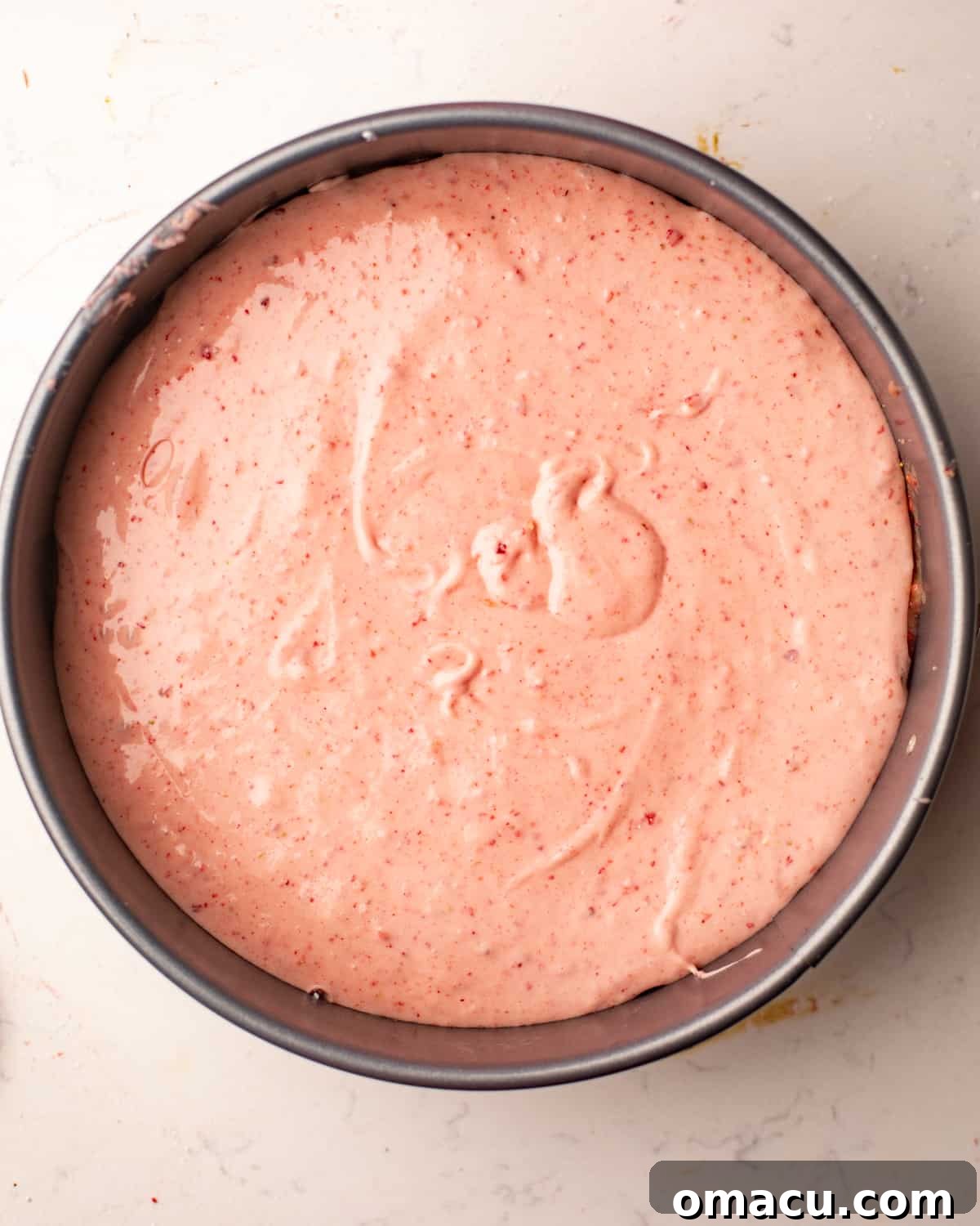 Strawberry butter cake baking in a springform pan, showing the browned top crust and jiggly center.