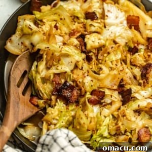 fried cabbage in a pan topped with bacon.
