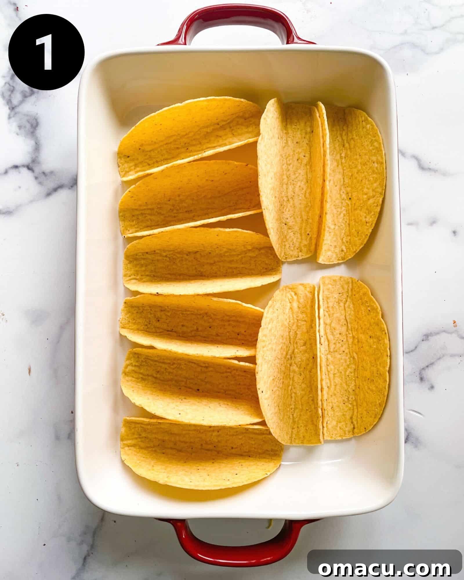 Crisp hard taco shells neatly lined up in a 9x13 inch baking pan, ready for their initial bake to achieve maximum crispness.