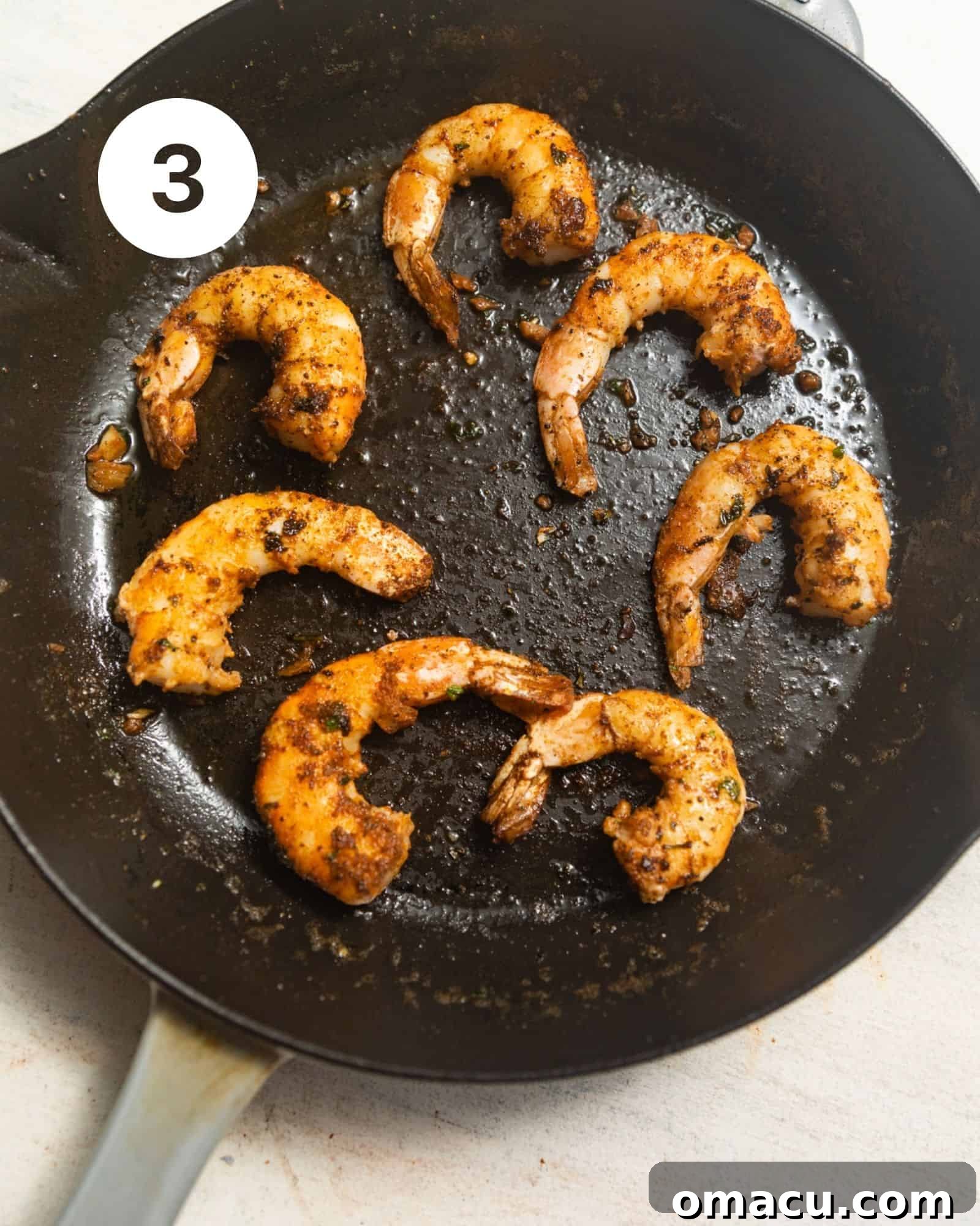 Succulent shrimp, showing a perfect sear, cooking in a hot skillet with melted butter and fragrant garlic.