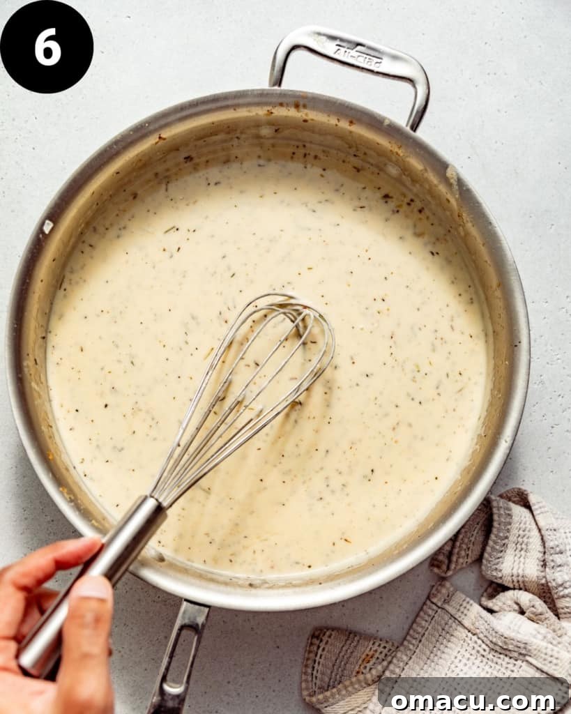 white wine sauce in a pan with a whisk.