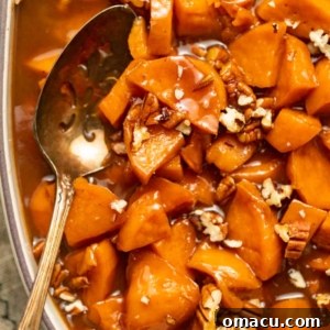 Sweet and glossy candied sweet potatoes presented in a classic casserole dish, accompanied by a serving spoon, ready for the holiday table.