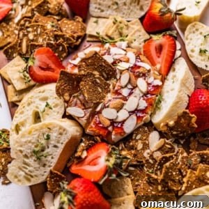 A serving of warm baked brie topped with sweet jam, presented on an elegant cheese board.