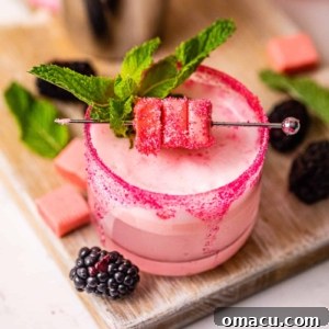 A vibrant pink starburst drink, garnished with fresh berries, artfully arranged on a serving board.