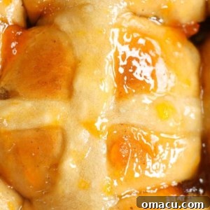 A close-up view of traditional hot cross buns, featuring their characteristic cross on top, indicating a delightful Easter treat.