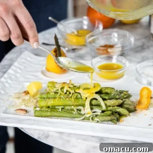 Perfectly cooked asparagus spears drizzled with a vibrant champagne citrus vinaigrette, a light and refreshing spring appetizer.