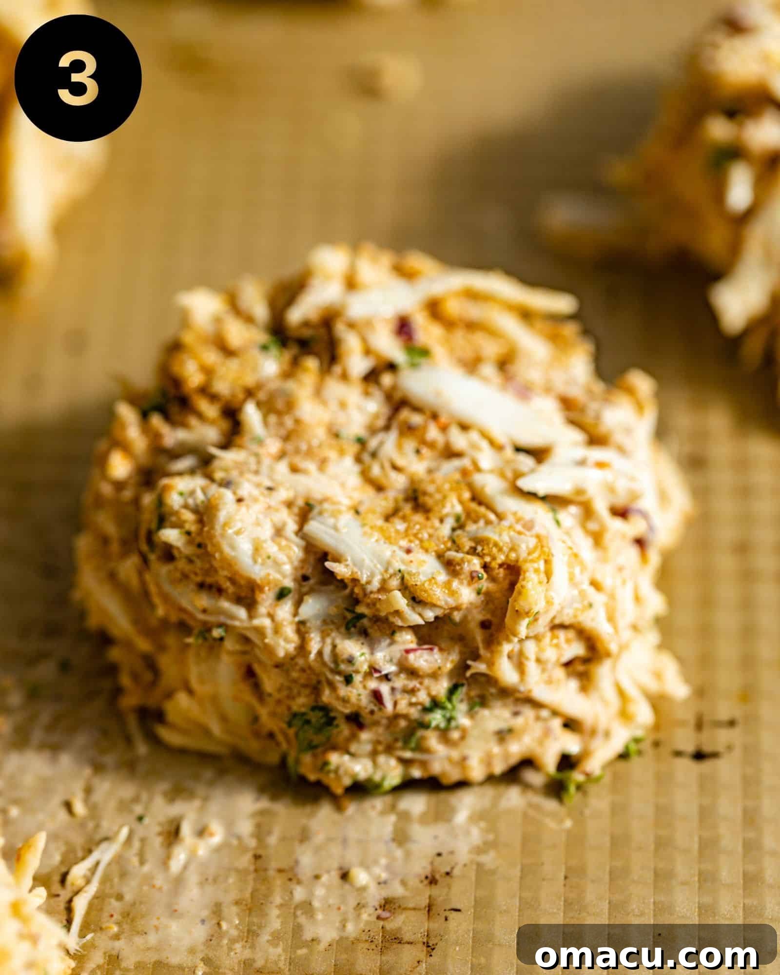 Crab cakes neatly formed with a measuring cup and placed on a lined baking sheet, ready for chilling.