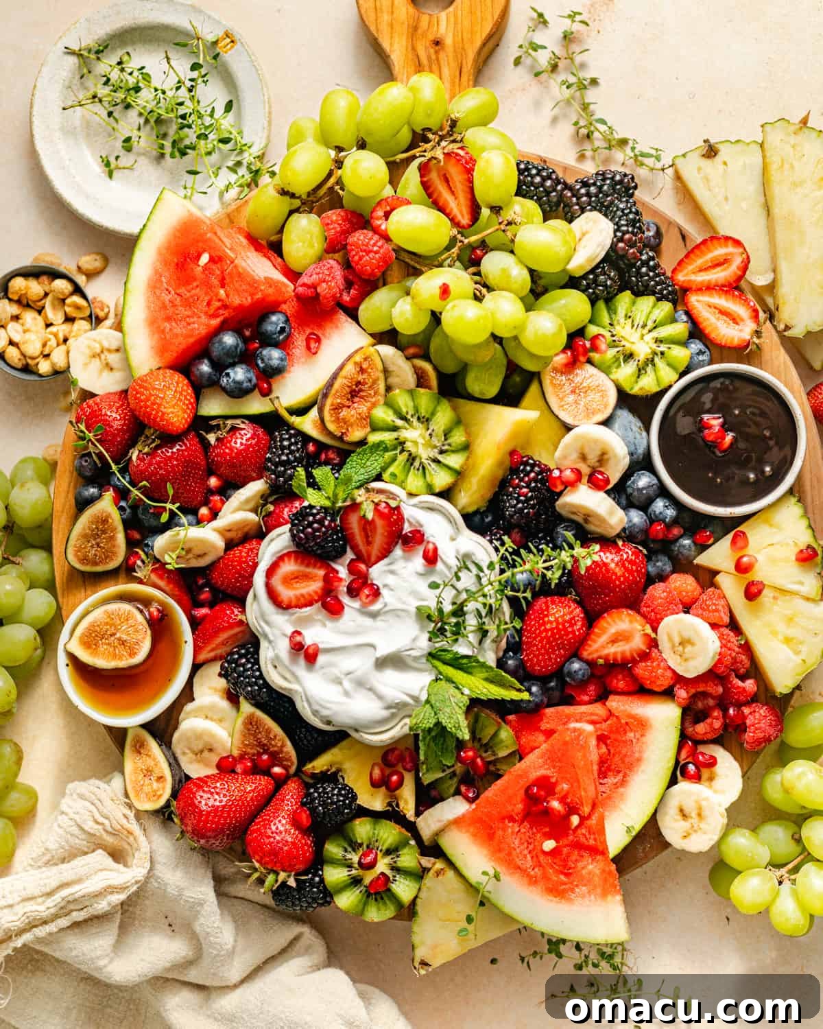 A vibrant fresh fruit charcuterie board overflowing with a variety of colorful fruits and creamy dips, beautifully arranged on a rustic wooden tray, ready for serving.