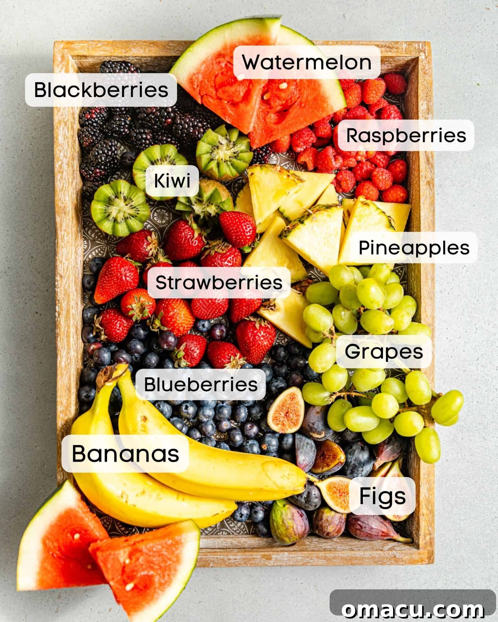 Ingredients for a colorful fruit charcuterie board displayed on a serving platter, featuring a variety of fresh and vibrant fruits.