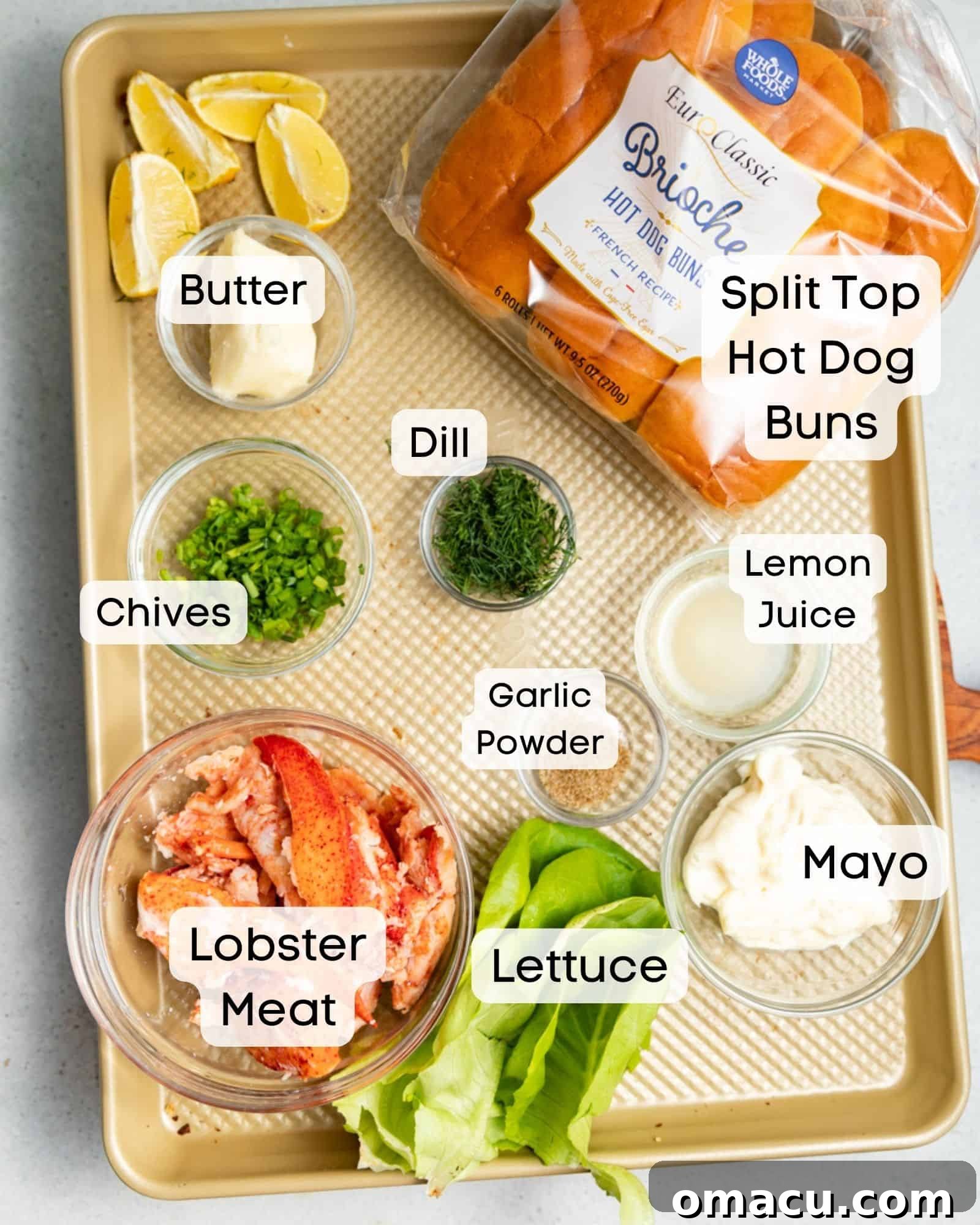 All ingredients laid out to make lobster rolls: fresh lobster meat, split-top hot dog buns, crisp lettuce, creamy mayo, fresh lemon juice, various seasonings, melted butter, fresh chives, and aromatic dill.