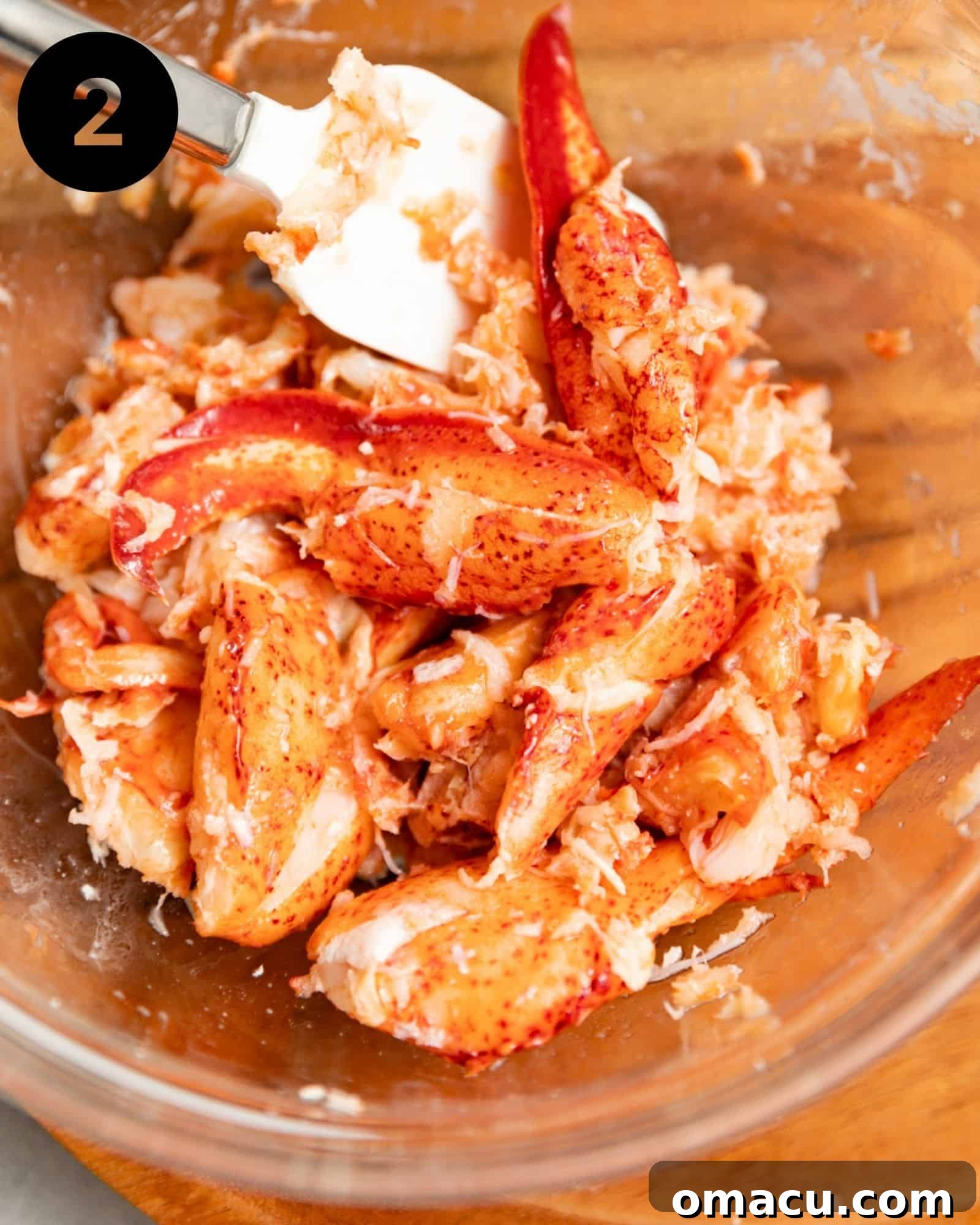 Succulent lobster meat in a bowl, glistening after being tossed in melted butter and seasonings, ready for the dressing.