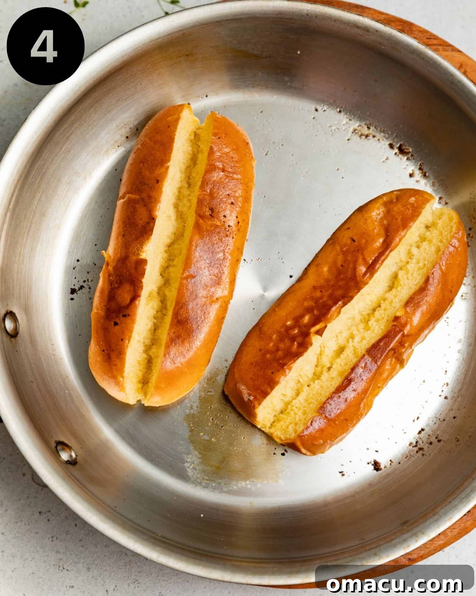 Split-top hot dog buns perfectly toasted to a golden brown in a skillet with melted butter, ready for filling.