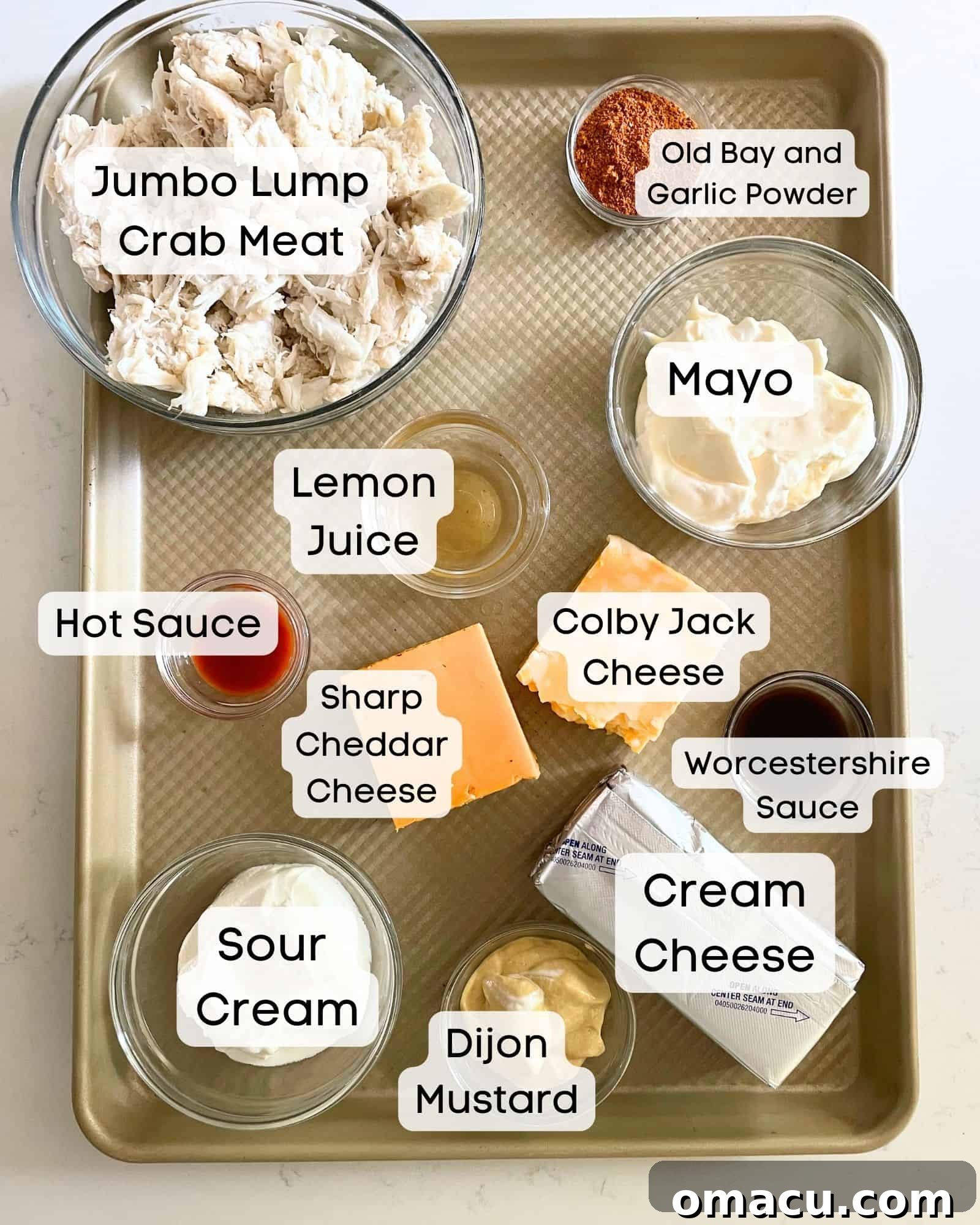 A vibrant flat lay of all the essential ingredients for making the ultimate crab dip: fresh jumbo lump crab meat, creamy mayonnaise, tangy sour cream, Old Bay seasoning, Dijon mustard, aromatic garlic powder, a blend of sharp cheddar and Colby Jack cheeses, soft cream cheese, bright lemon juice, savory Worcestershire sauce, and a hint of hot sauce.