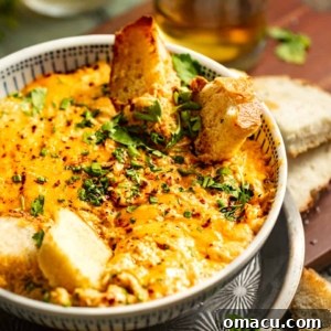 maryland crab dip in a bowl with two glasses behind it.
