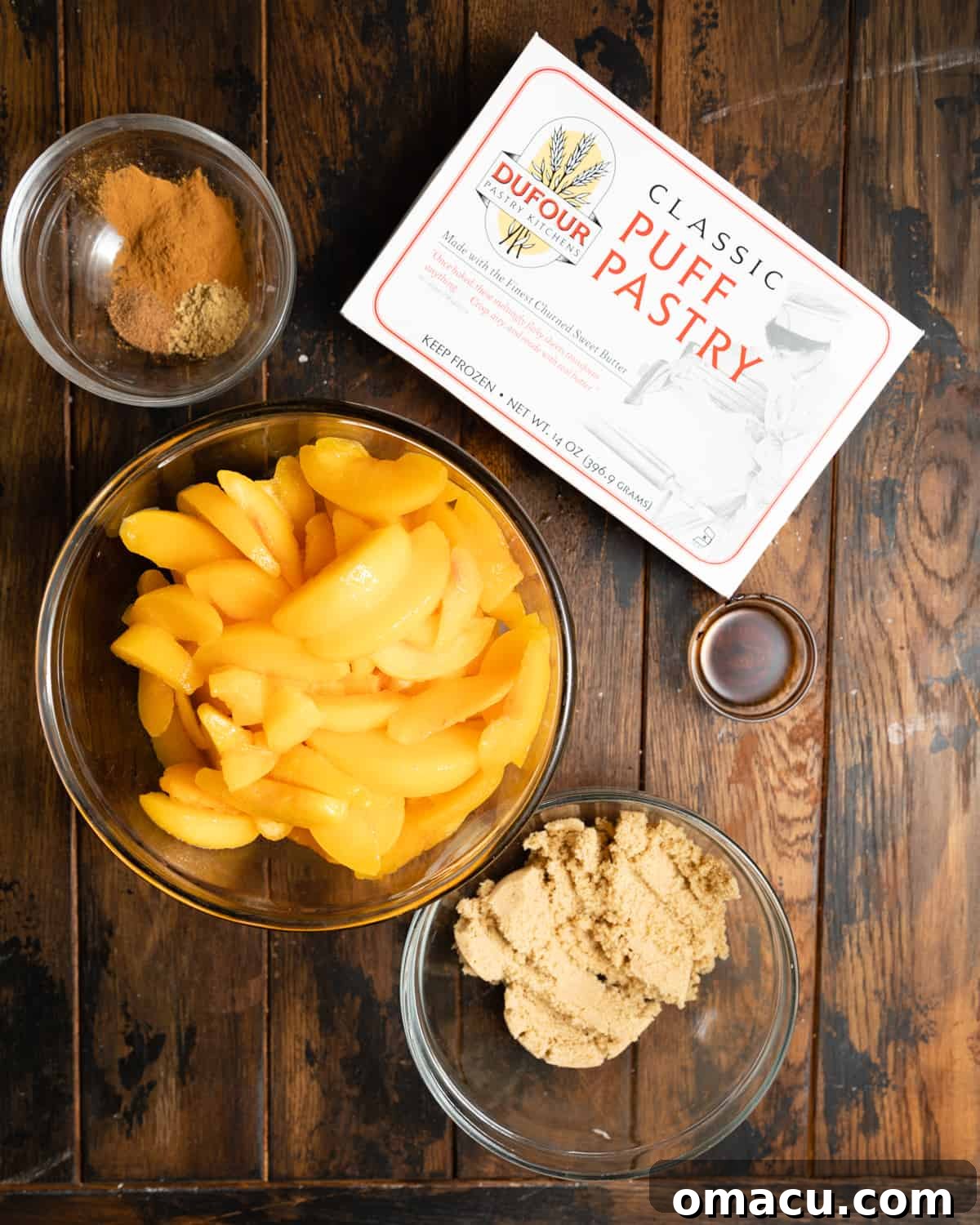Ingredients laid out on a wooden table, ready to make a rustic peach galette.