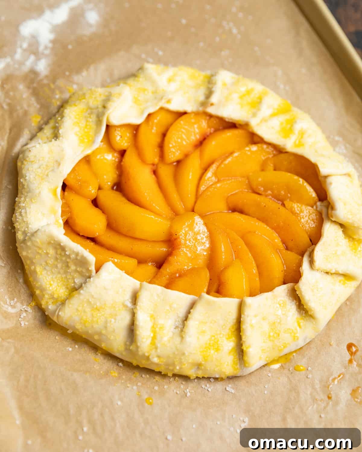 Puff pastry folded into a galette around peaches and brushed with egg wash.